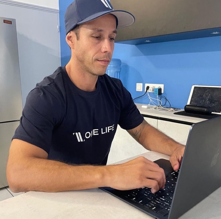 Cassio at his desk in a One Life shirt